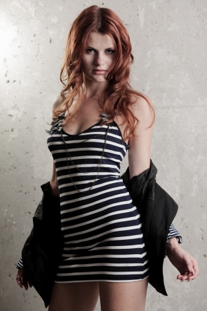 Fashion sensual portrait of young sexy redhead girl over grunge wallの写真素材