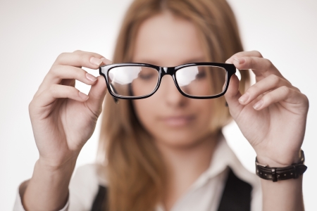 Girl holding glasses, selective focus on glasses  Concept  poor eyesightの写真素材