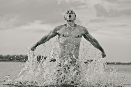 Handsome muscular guy jumping from water. Black and whiteの写真素材