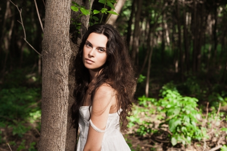 Portrait of young brunette girl in forest  Copy space on rightの写真素材
