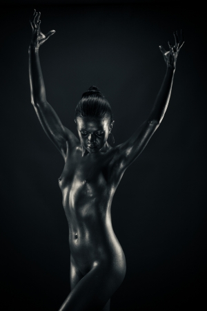 Nude metallic woman holding something invisibleの写真素材