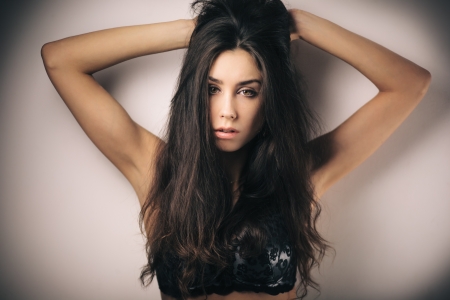 Fashion portrait of young sensual brunette girl with long beautiful hair on whiteの写真素材