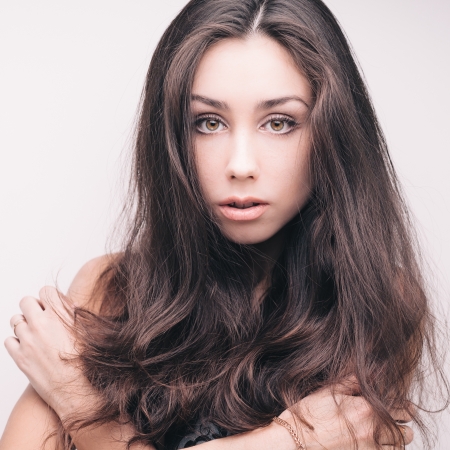 Fashion portrait of young sensual brunette girl with long beautiful hair on whiteの写真素材