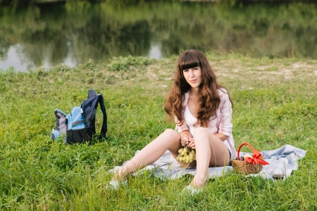 Young brunette woman enjoying picnic near the riverの写真素材