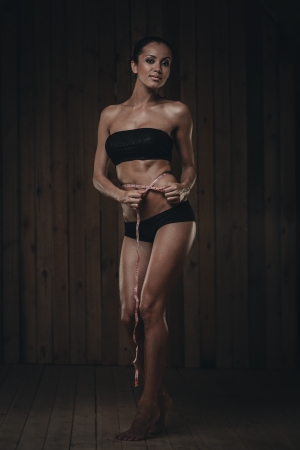 Fit gorgeous brunette with measuring meter on waistの写真素材