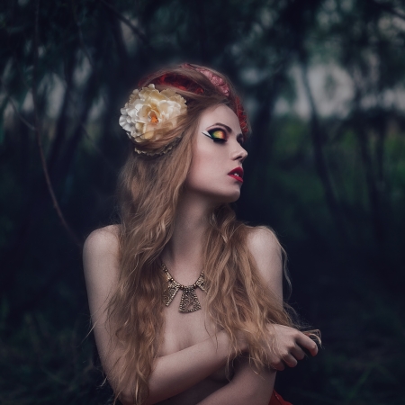 Art fashion portrait of young blond girl with flowers in hair on meadowの写真素材