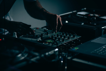 Male dj at work in night club. Shallow depth of field