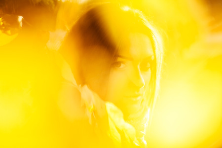 Silhouette of woman face. Shot through leaves.Abstract concept of autumn mood. No sharpnessの写真素材