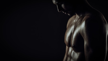 Young athletic brutal man on black backgroundの写真素材