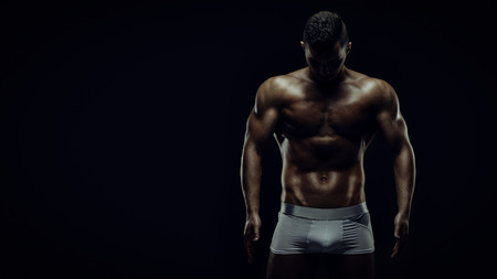 Young athletic brutal man on black backgroundの写真素材