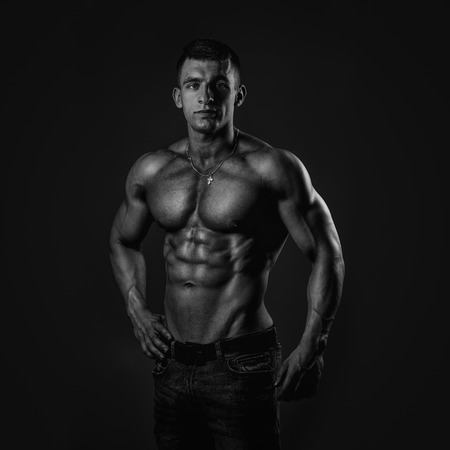 Athletic young shirtless muscular man in jeansの写真素材