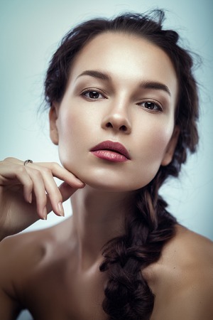 Fashion portrait of gorgeous young brunetee woman.Chaos hair style with braid. Shallow depth of fieldの写真素材