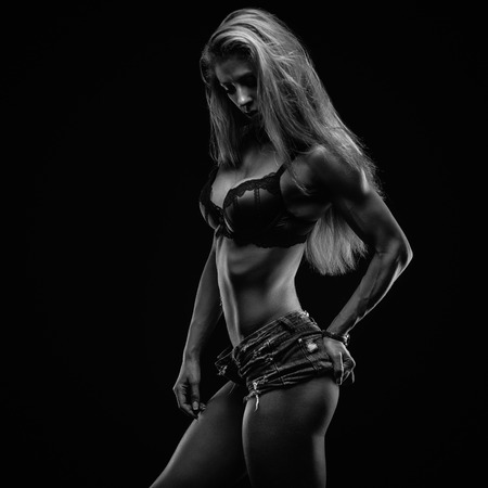 Fitness lady in studio on black backgroundの写真素材