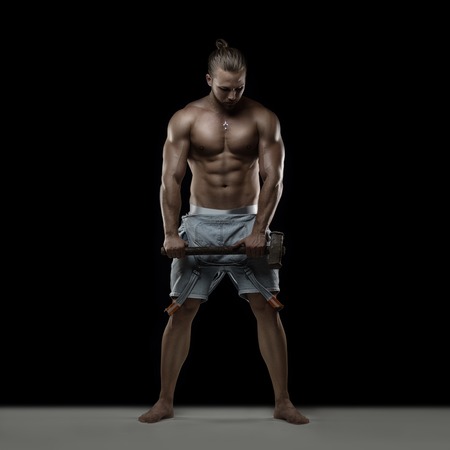Young muscular man posing on black backgroundの写真素材