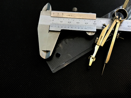 Compasses , ruler , Vernier Caliper used for the drawing , on the texture black background represent the tool and equipment concept related idea.の写真素材