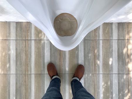 Man standing in front of urinal Top view of a man legs in front of urinal in men toiletの写真素材
