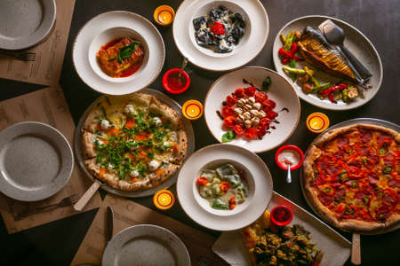 Top down view on enormous buffet of delicious freshly prepared european cuisine and pizza with menuの写真素材