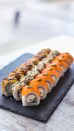 Sushi Set nigiri and sushi rolls on black stone slate plate board. place for tex stories format