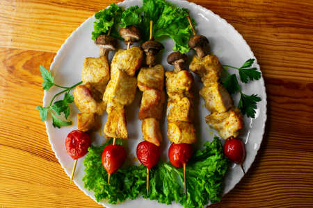 Grilled chicken on bamboo skewers with cherry, top viewの写真素材
