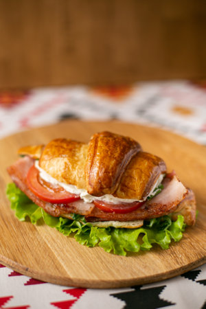 Croissant on a gray plate on a wooden background, top view