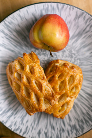 Homemade pastries freshly baked puff pastry puffs with apples on a plate close-up. Bakery products top viewの写真素材