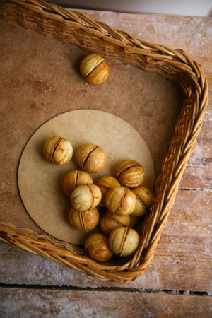Delicious walnut nut shaped cookies with boiled condensed milk on wood textured table, flat layの写真素材