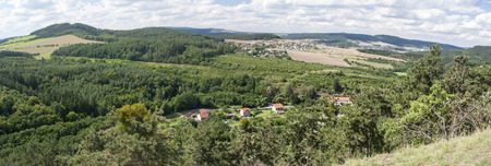 nice landscape of Cesky kras with small hills, village in vallesy, forests, meadows, fields and blue sky with clouds from Kotyz hillの写真素材