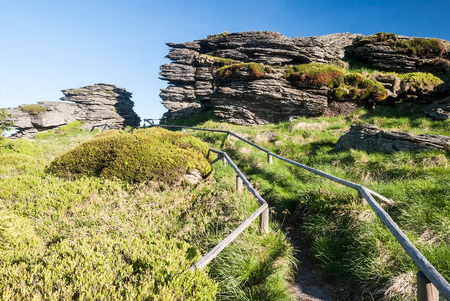 Vozka hill with schist rock formations, hiking trail with wooden barriers and clear sky in Jeseniky mountain range in Czech republicの写真素材