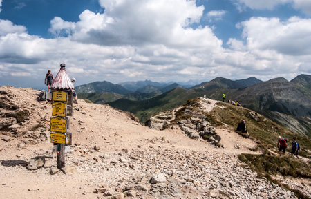 Zuberec, Slovakia â 8-19-2017: beautiful summer day on Volovec mountain peak in Zapadne Tatry mountains on slovakian-polish borders with signpost, few hikers, scenery of Tatra mountains and blue sky with cloudsのeditorial素材