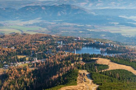 Strbske Pleso with lake, colorful forest around and Kozie chrbty mountain range on the background in...