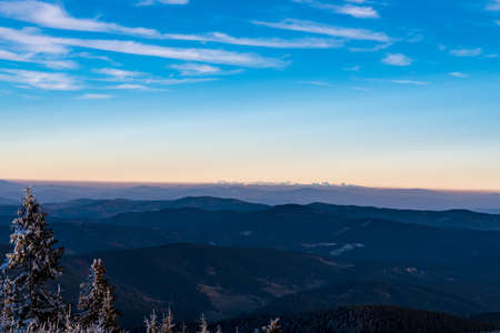 View to Tatra mountains from Lysa hora hill in Moravskoslezske Beskydy mountains in Czech republic during late autumn sunsetの写真素材