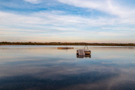 Karvinske more lake with swiming piers with stairs near Karvina city in Czech republic during beautiful day with blue sky and cloudsの写真素材
