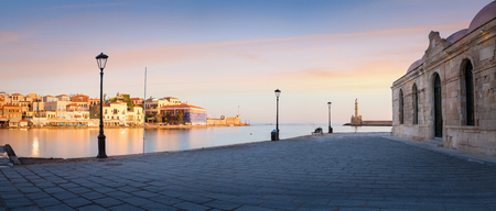 Panorama of Old harbor of Chania with the lighthouse, bench and lamp with beautiful sky at sunrise, Crete, Greeceの写真素材