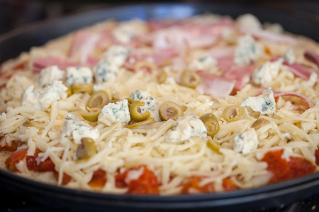 Preparation of authentic homemade cheese and bluecheese pizza with green olivesの写真素材