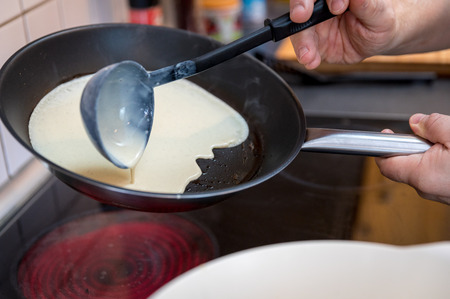 cooking pancakes dough on the pan at home environmentの写真素材