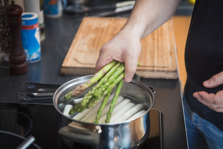 boiling green and white asparagus in the potの写真素材