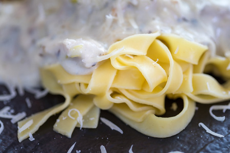 Pasta with cheese sauce on dark plateの写真素材
