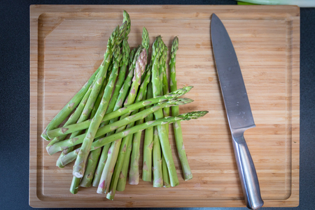 Green asparagus with knife on wooden backgroundの写真素材