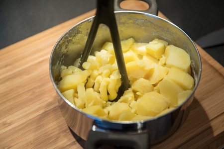 Mashed potatoes preparation in the pot on wooden backgroundの写真素材