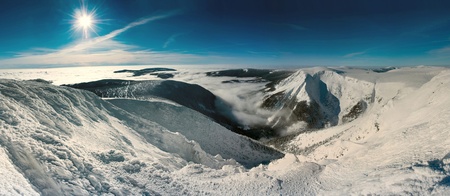 Scenic view of sun shining over snow covered Giant mountains, Czech Republic. 