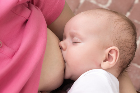 Soft portrait of a mother breastfeeding her cute baby, girl.の写真素材