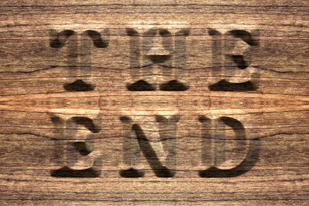The end, sign on a seamless rustic wooden board, embossed letters.の写真素材