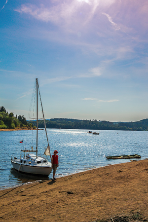Small boat at shore of the small lake, late afternoon. Lake Orlik, 100 km south of Prague.の写真素材