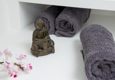 a still life with buddha figure, orchid blossom and towelの写真素材