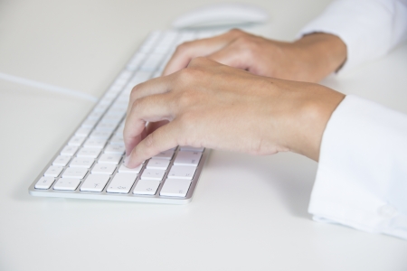 hands of a woman typing on a keyboardの写真素材