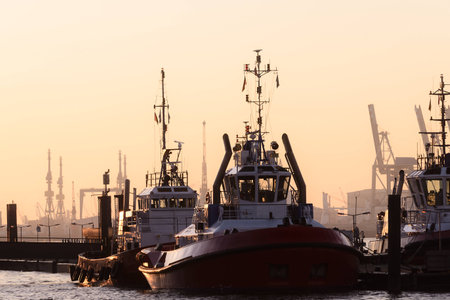 Two tugboats moored in a harbour at sunsetの写真素材