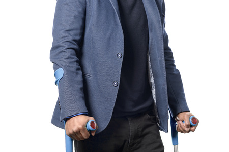 Disabled african man in blue jacket Walking with Two Crutches, Isolated on White Background.の写真素材