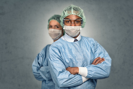 Confident Male and Female Medical Professionals Smiling at the Camera wearing blue scrubs and sterility capの写真素材