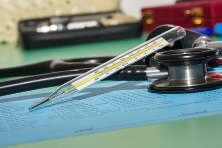 thermometer otoscope and stethoscope on the lap sheet
