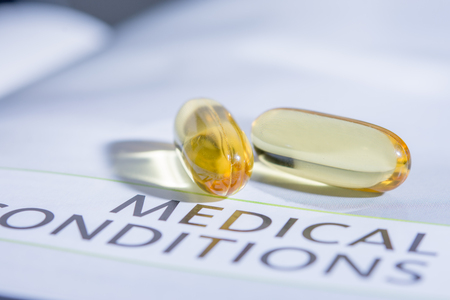 gold capsule drug on the book concept healthcareの写真素材